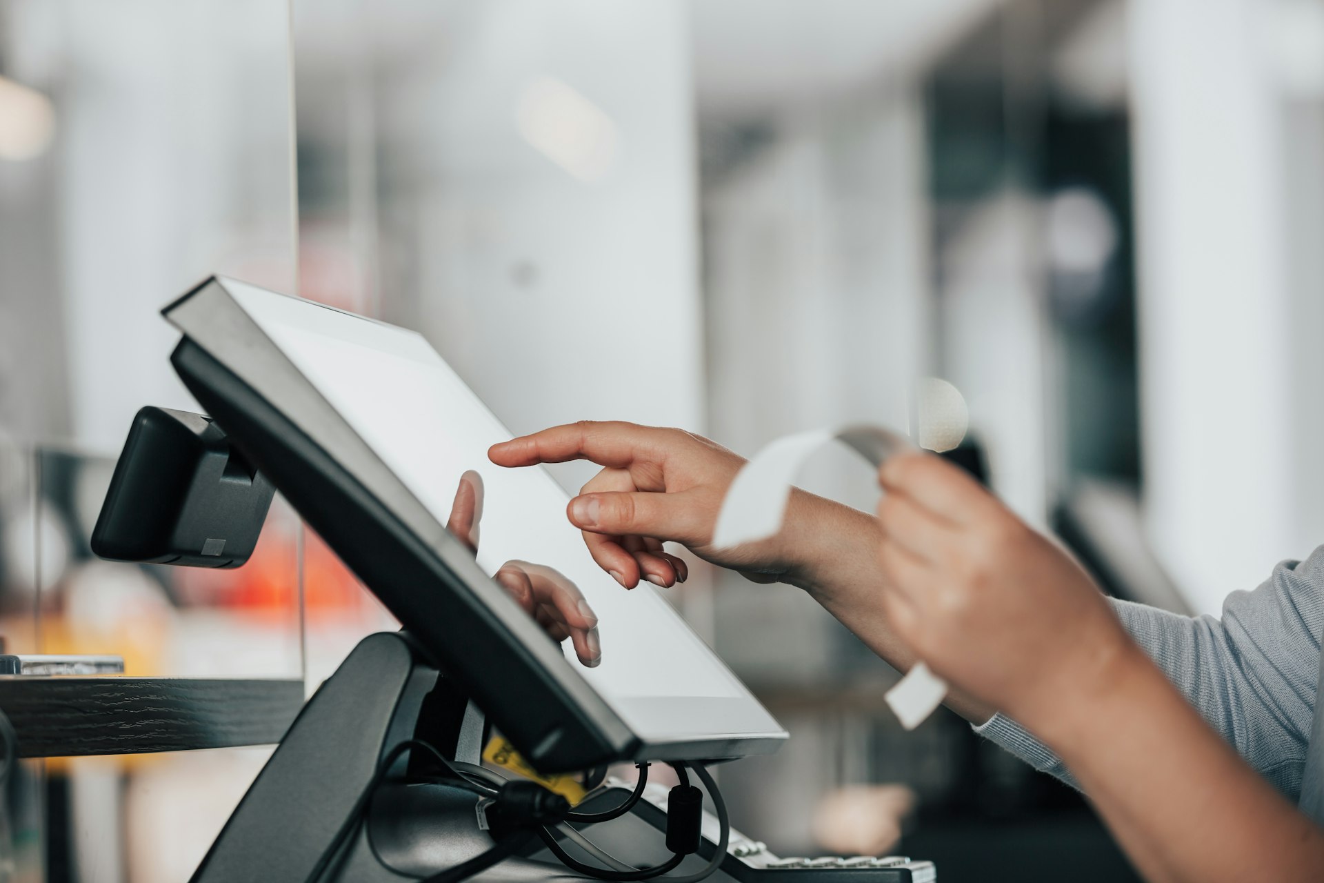 Cashier using a touchscreen POS at checkout