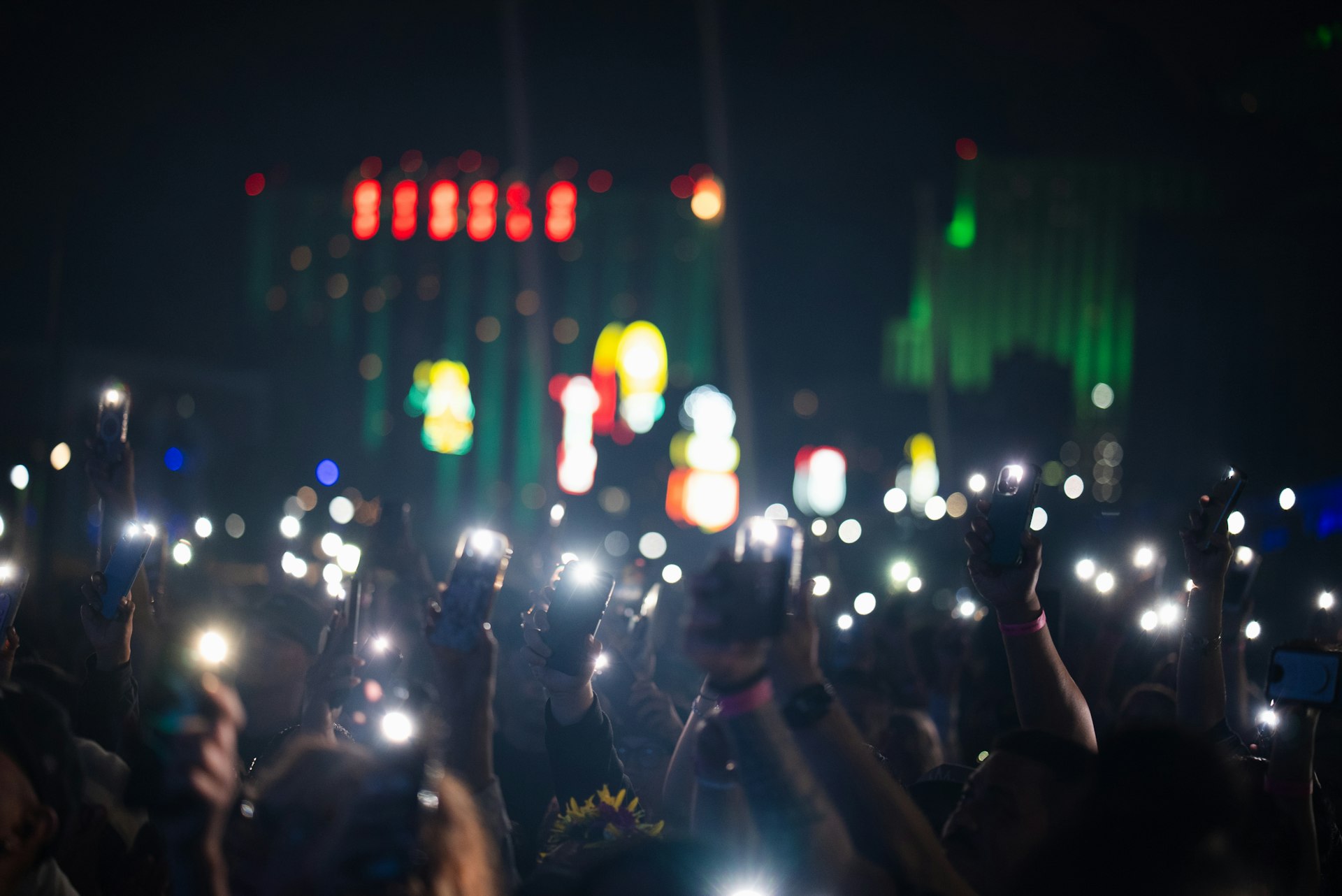 Crowd holding up phones at a live event